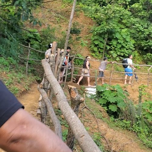 Sendero de palos de algarrobo en la reserva La Ceiba guiando a una familia piurana hacia la Cueva de la Leona
